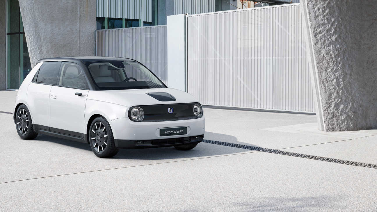 Trojštvrťový pohľad spredu na model Honda e zaparkovaný pred budovou v noci