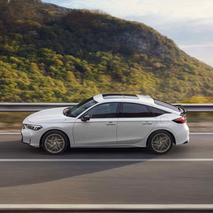 Honda Civic Hybrid v pohybe na diaľnici s malebným výhľadom.