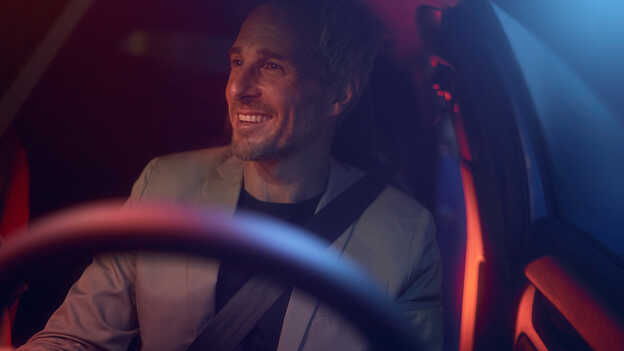 Detailný záber na muža sediaceho za volantom vozidla. 