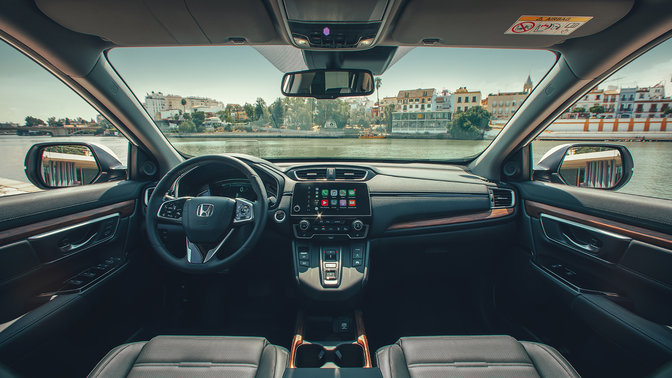 Detailný záber na palubnú dosku v interiéri vozidla Honda CR-V Hybrid na ulici.
