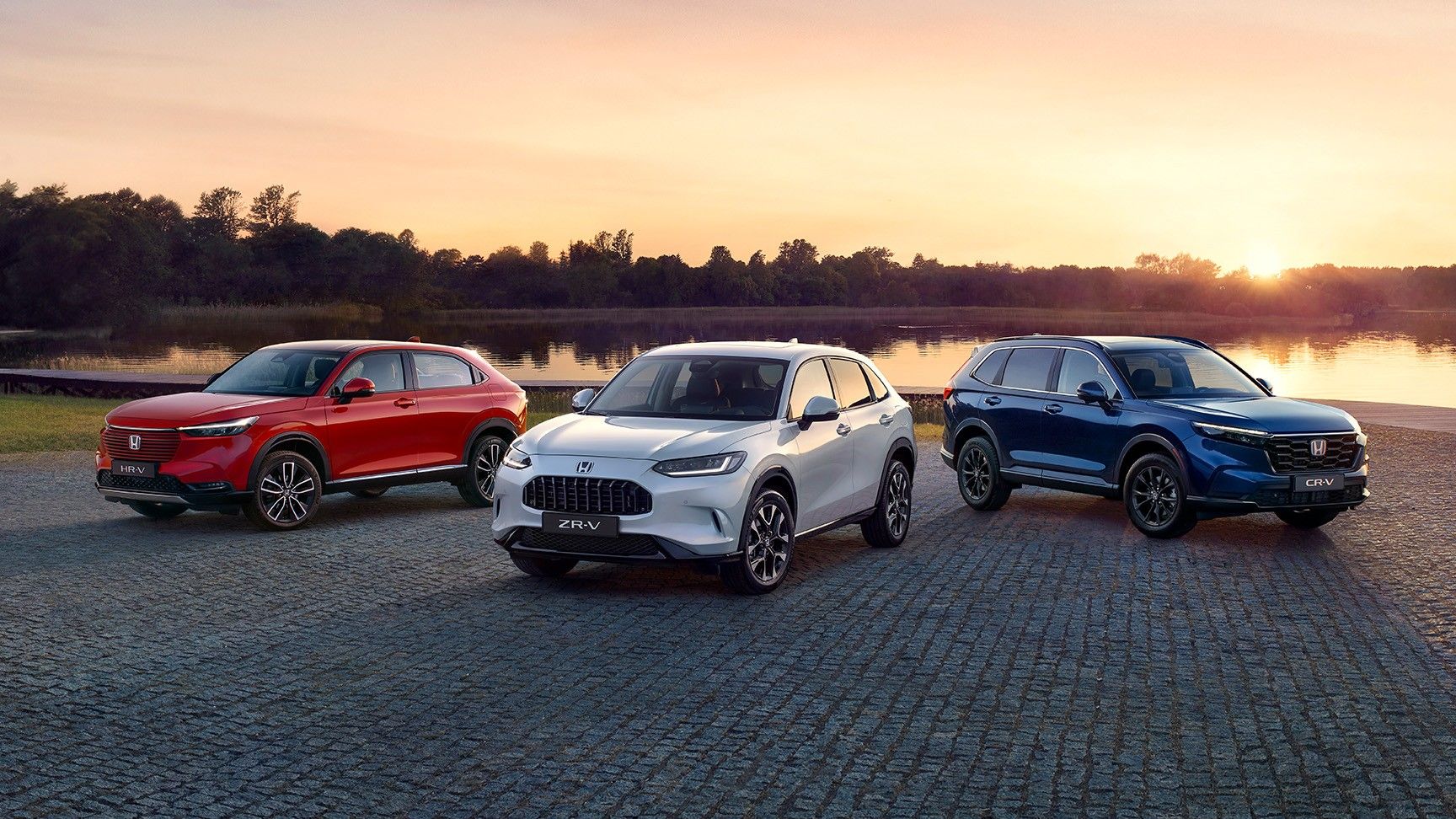 Ponuka hybridných vozidiel Honda zaparkovaných pred panorámou mesta