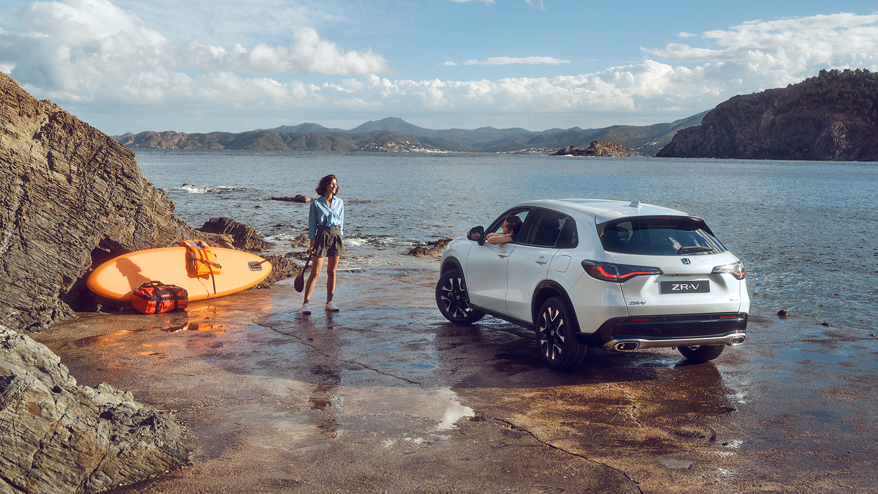 Biele vozidlo ZR-V na pobreží so ženou a kanoe