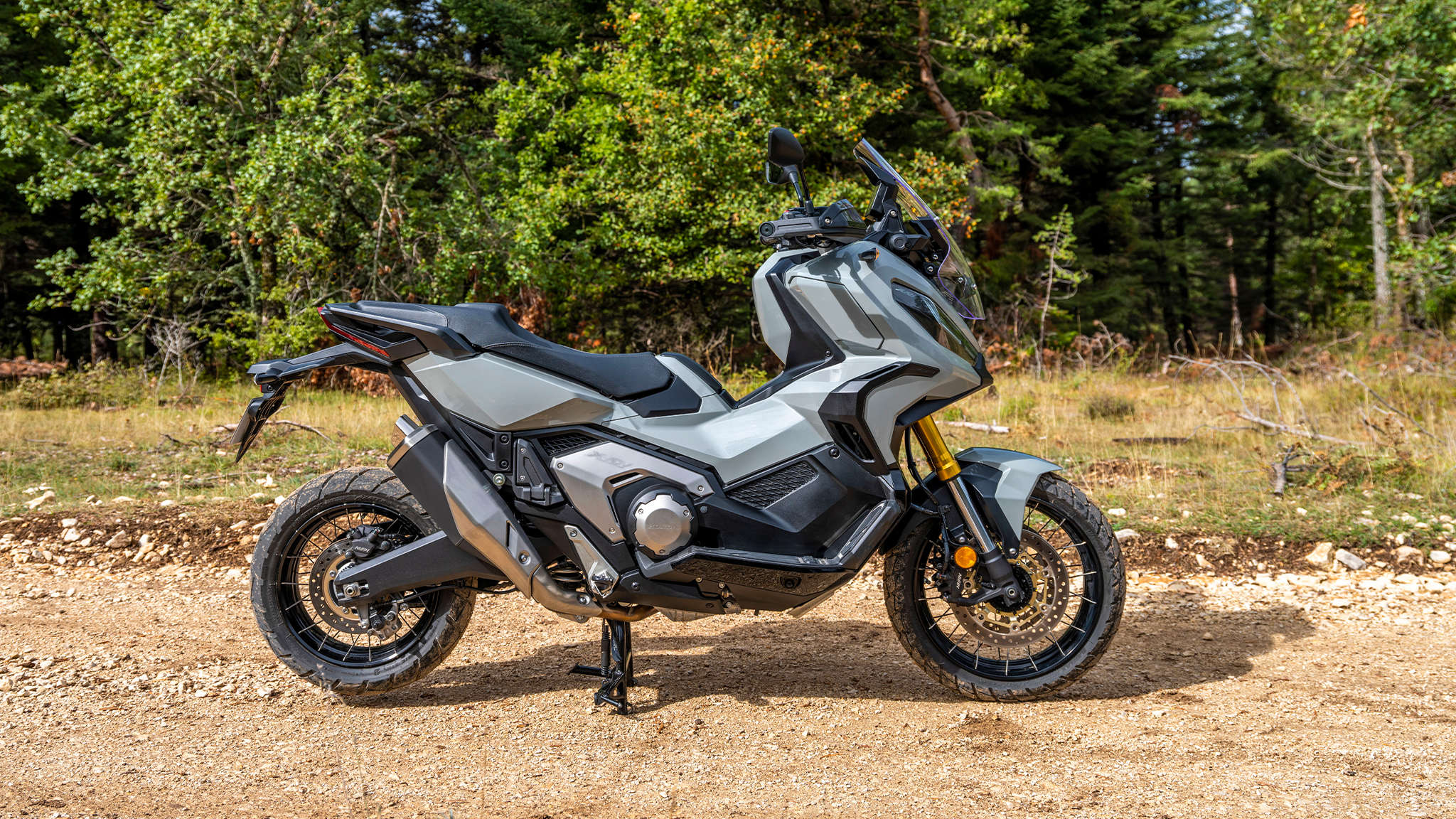 Honda X-ADV, sivý motocykel na lesnej ceste