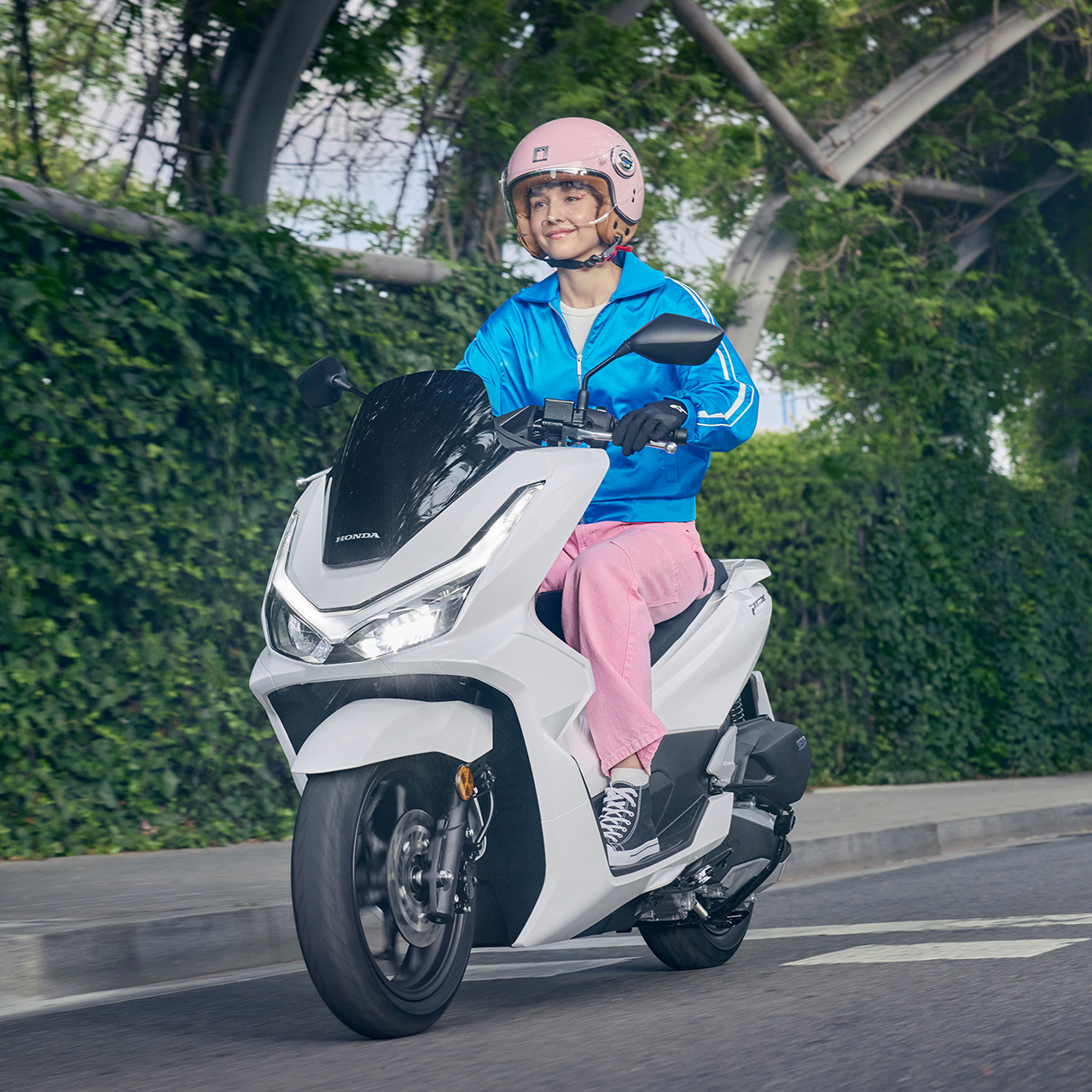 Figurant pri jazde na skútri PCX125 v meste