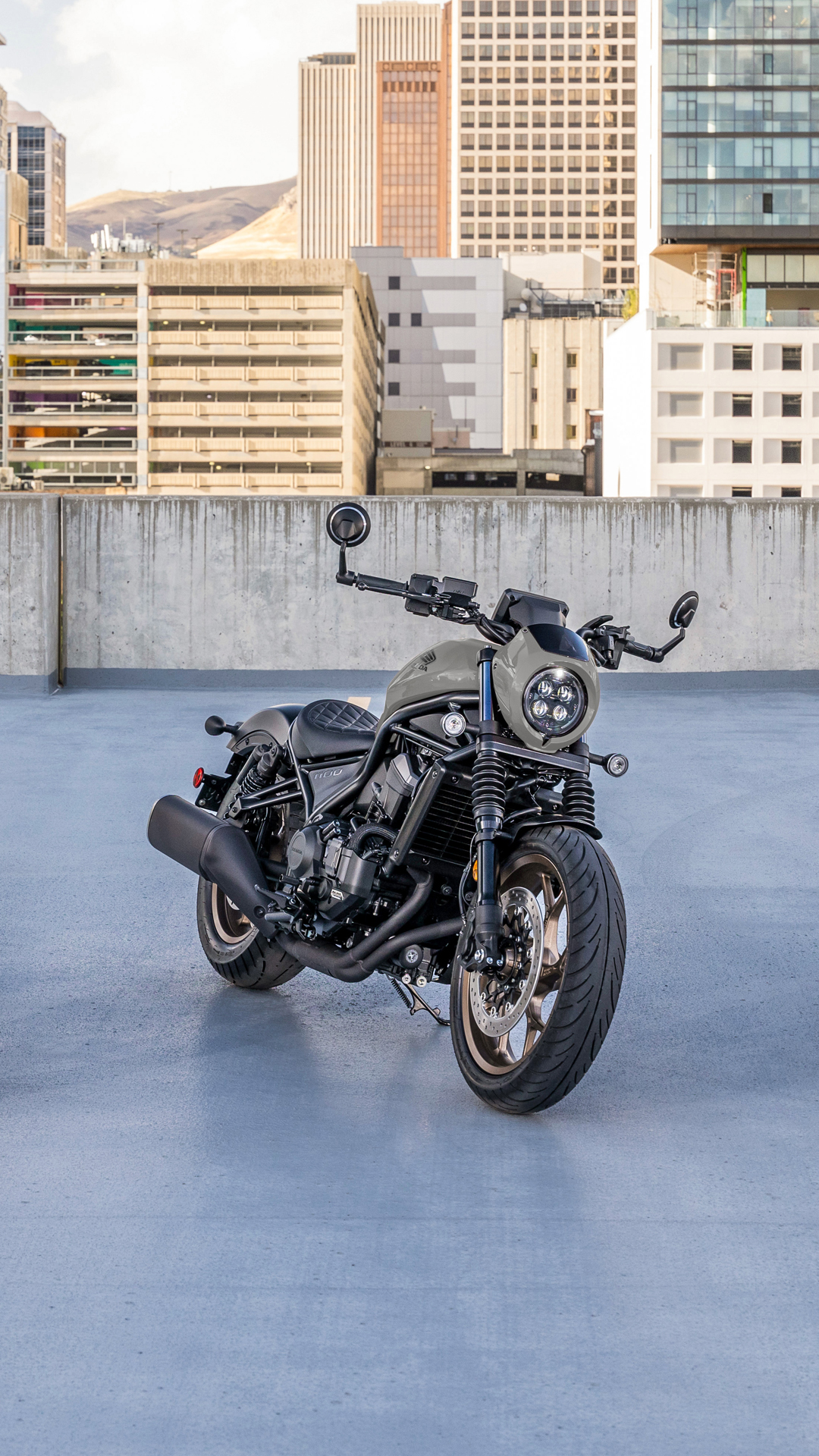 Motocykel CMX1100 vonku, pred modernou budovou.