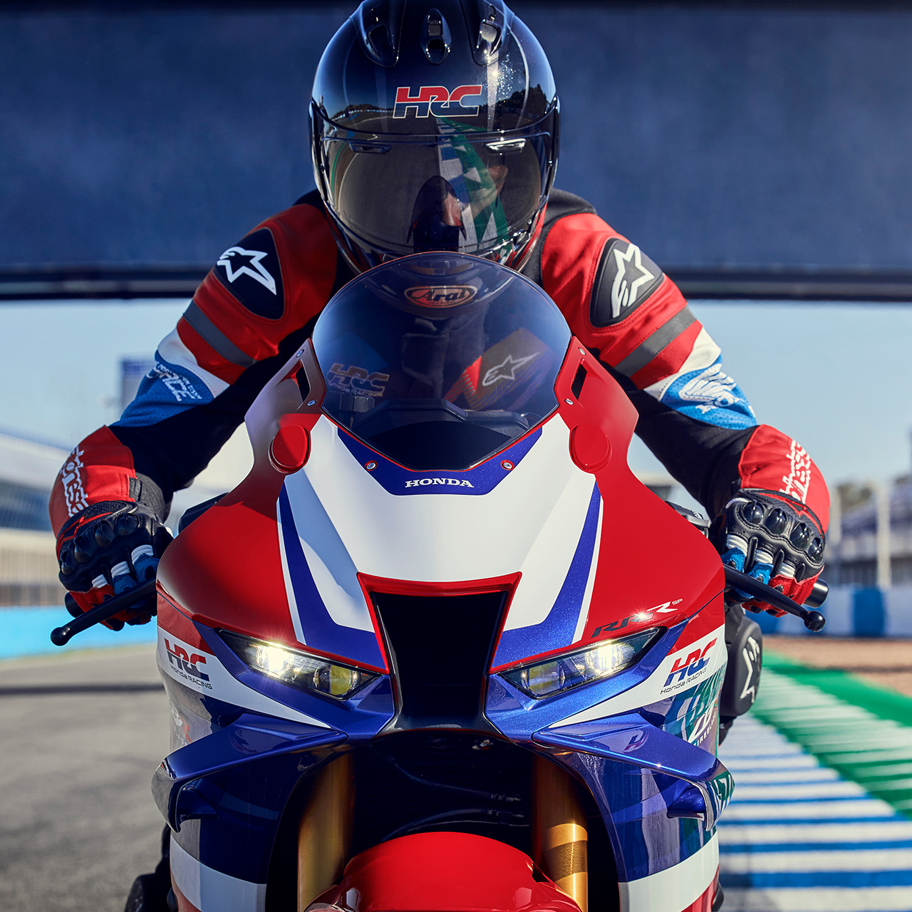 Detailný pohľad spredu na jazdca na modeli Honda CBR1000RR-R Fireblade na pretekárskej trati. 