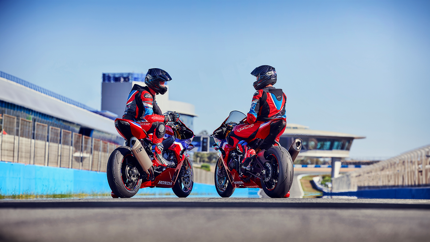 Pohľad zozadu na dvoch motocyklistov s Hondou CBR1000rr-r Fireblade na pretekárskej trati. 