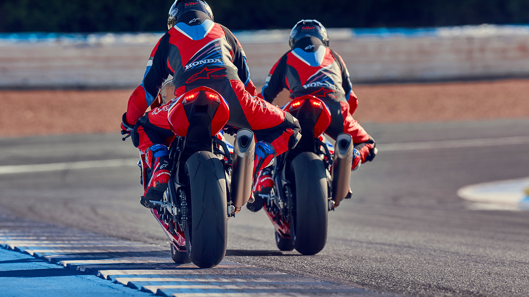 Pohľad zozadu na dvoch motocyklistov s Hondou CBR1000rr-r Fireblade na pretekárskej trati. 