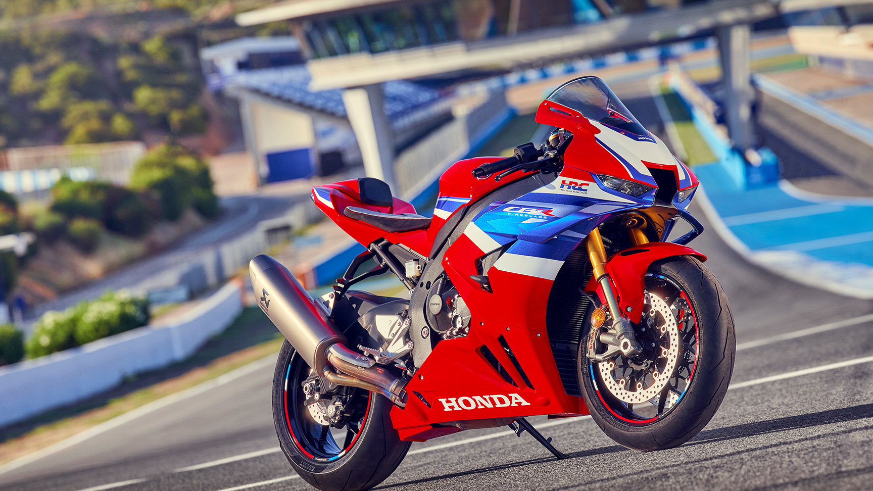 Trojštvrťový záber spredu na model Honda CBR1000rr-r Fireblade zaparkovaný na pretekárskej dráhe. 